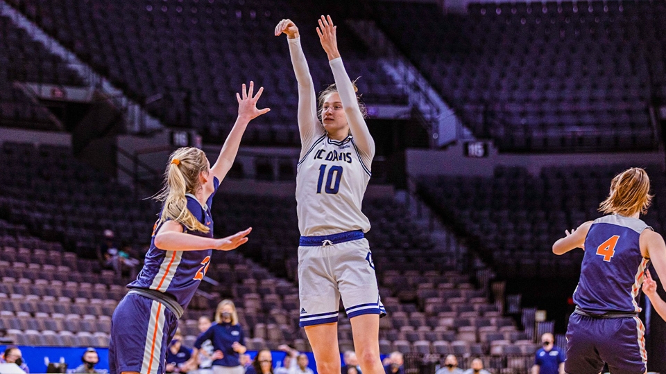 Lena Svanholm shooting a basketball towards the hoop with opposing team member playing defense
