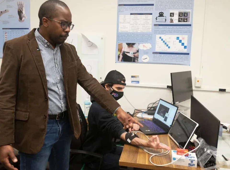 Neuroscientist Wilsaan Joiner points to an ultrasound machine.